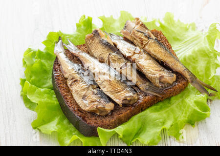 Poisson délicieux sandwich avec du pain et de sprats en conserve Banque D'Images