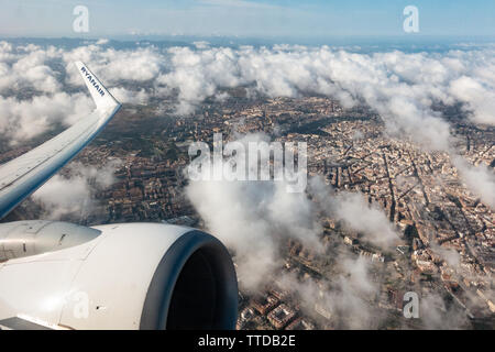 Vue montrant le moteur à réaction et de bout d'aile d'un Boeing 737 passagers ryanair voler au-dessus des nuages à ville ci-dessous Banque D'Images