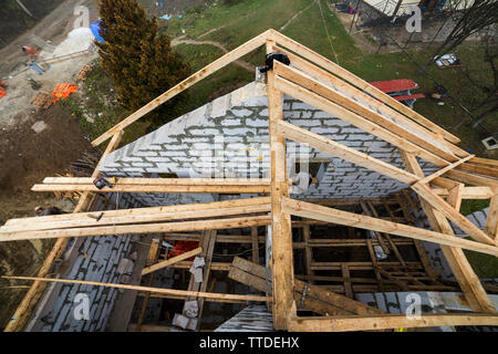 Vue de dessus du châssis de toit en bois poutres de bois et de planches sur les parois en blocs isolants en mousse creux. Bâtiment, construction, toitures et renovat Banque D'Images