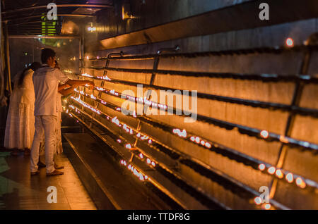 Une femme allume une bougie dans un temple de Kataragama, Sri Lanka Banque D'Images