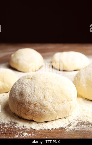 Boules de pâte à pizza sur planche en bois farinée Banque D'Images