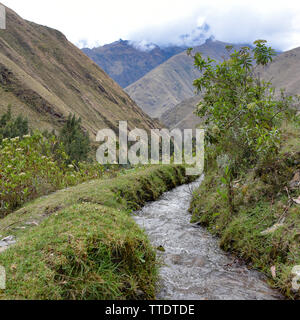 Canaux d'irrigation antiques transportant de l'eau glaciaire des terres agricoles dans la vallée de l'Urubamba. Cusco, Pérou Banque D'Images