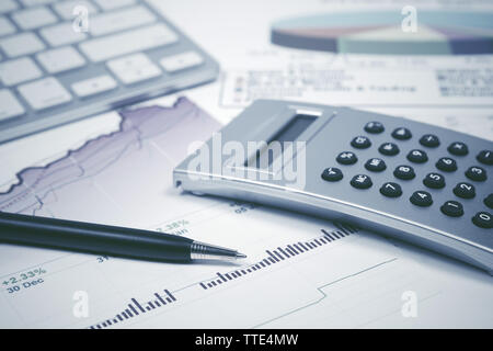 Stylo et calculatrice comptabilité financière sur les graphiques et tableaux Banque D'Images