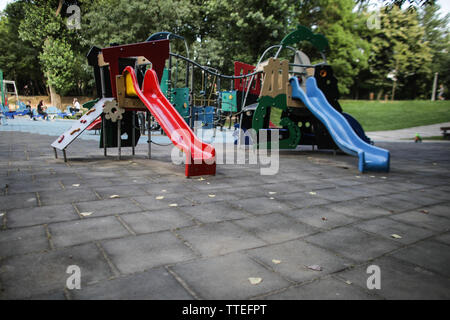 Aire de jeux pour enfants avec des toboggans, balançoires et autres objets. Banque D'Images