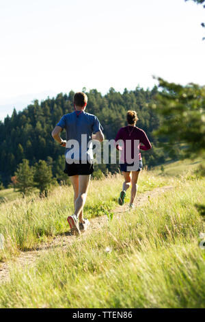 Un couple millénaire trail running ensemble au début de la lumière du matin. Une partie de leur propre, actif, mettre en place, et d'un style de vie sain. Le Montana, USA. Banque D'Images