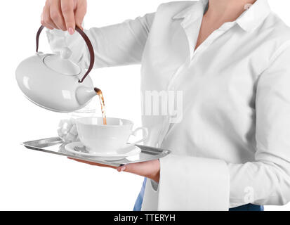 Waiter pouring tea en tasse sur fond blanc Banque D'Images