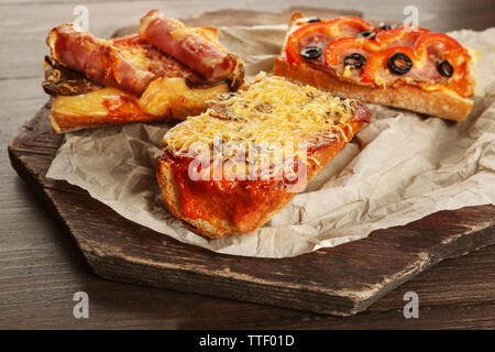 Pizza chaude baguettes au jambon, bacon et le salami sur table en bois Banque D'Images