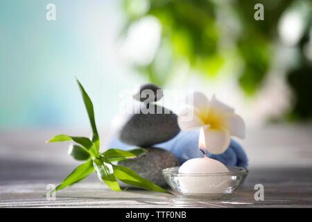 Pierres Spa avec une serviette, une fleur tropicale, bambou et bougie sur arrière-plan flou Banque D'Images