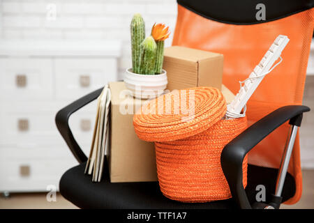 L'osier et des boîtes en carton avec des choses pour la réinstallation sur une chaise Banque D'Images