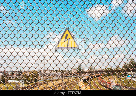 Panneau jaune de danger sur la clôture, la grille Banque D'Images