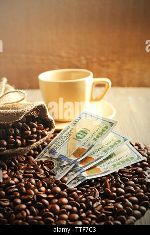 Les grains de café, tasse et billets en dollars US sur fond de bois Banque D'Images