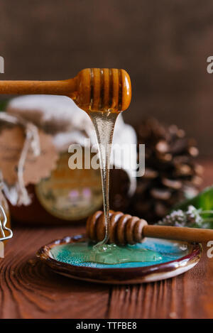 Close-up de miel Le cincle dans la plaque sur une table en bois contre le mur Banque D'Images