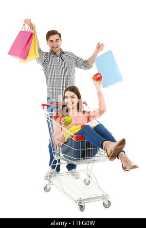 En couple avec chariot métallique et produits colorful shopping bags isolated on white Banque D'Images