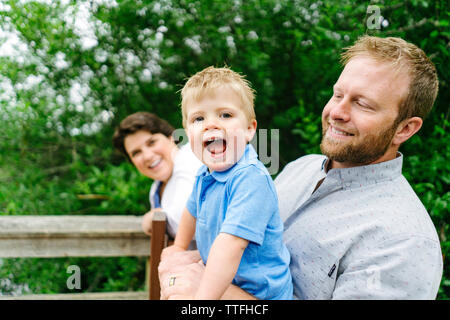 Tout droit sur portrait d'un jeune garçon rire avec sa famille Banque D'Images