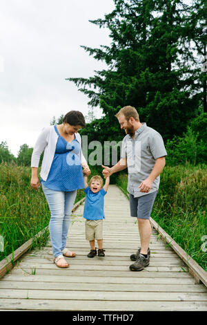 Tout droit sur portrait d'une famille de jouer ensemble tout en se tenant la main Banque D'Images