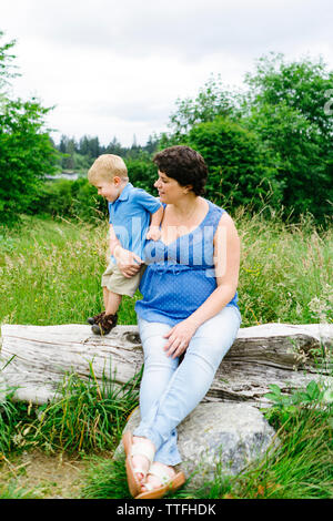 Tout droit sur portrait d'une maman et son fils assis sur un journal de grève Banque D'Images
