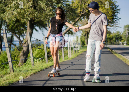 Les jeunes de la génération Y sur le croiseur skateboards patinage de piste cyclable Banque D'Images