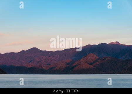 Vue panoramique sur le lac Chuzenji contre Mt Nikko-Shirane au cours de l'automne au coucher du soleil Banque D'Images