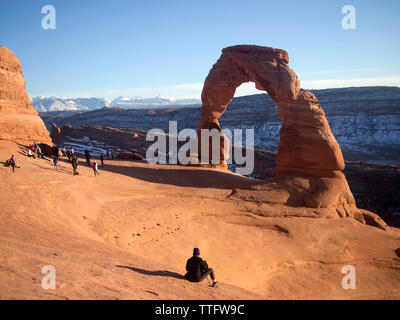 Une foule se rassemble au coucher du soleil à Delicate Arch. Banque D'Images