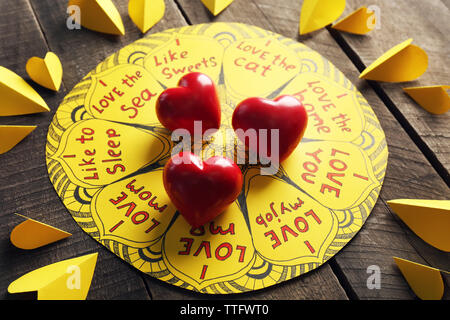 Valentine jaune avec des inscriptions et coeurs rouges sur fond de bois Banque D'Images