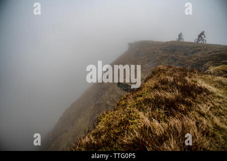 Un homme et une femme ride vtt sur une piste escarpée près de fan-y-grand dans le parc national de Brecon Beacons, le Pays de Galles. Le vélo de montagne. Banque D'Images