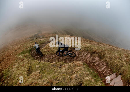 Un homme et une femme ride vtt sur une piste escarpée près de fan-y-grand dans le parc national de Brecon Beacons, le Pays de Galles. Le vélo de montagne. Banque D'Images