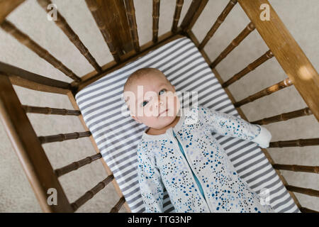 Vue de dessus de la pose bébé dans un berceau en bois Banque D'Images