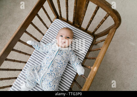 Pose bébé dans un berceau en bois Banque D'Images