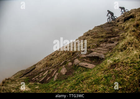 Un homme et une femme ride vtt sur une piste escarpée près de fan-y-grand dans le parc national de Brecon Beacons, le Pays de Galles. Le vélo de montagne. Banque D'Images