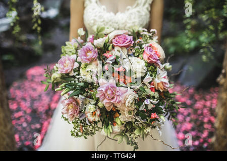 Beau bouquet de mariage coloré dans la main de la mariée. Déco a de roses pivoines et tulipes. Corail rose et couleurs délicates. Banque D'Images