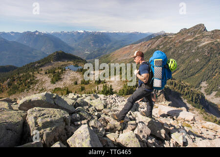 Backpacker s'arrête pour regarder la vue d'un rocky mountain Ridge, Banque D'Images