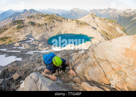 Un grimpeur monte haut sur l'étape rocheuse Pointe Douglas, en Colombie-Britannique. Banque D'Images