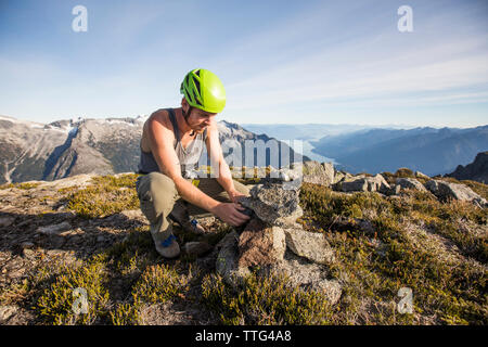 Climber construit un cairn sur la pointe Douglas, Colombie-Britannique, Canada Banque D'Images