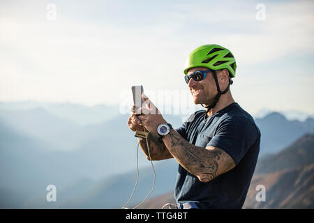 Man taking photo en mode paysage avec téléphone, en Colombie-Britannique. Banque D'Images