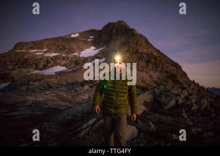 Projecteur port randonneur au crépuscule au-dessous de rocky mountain. Banque D'Images