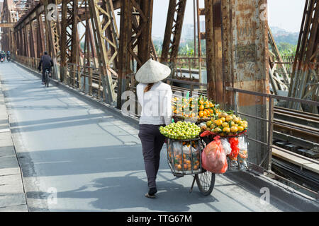 Vietnamienne portant des fruits sur son vélo Banque D'Images