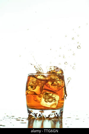 Ice cubes splashing in whiskey sur fond blanc Banque D'Images