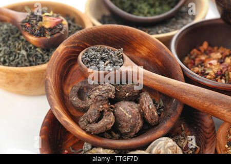 Variété de thé sec en pot et cuillère en bois, gros plan Banque D'Images