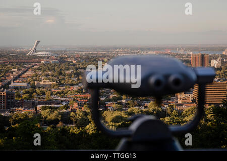 Close-up de jumelles à pièces contre ciel en ville pendant le coucher du soleil Banque D'Images