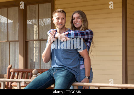 Western wear young couple holding sur le porche de la maison Banque D'Images