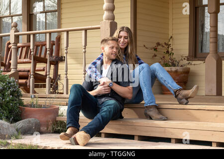 Deux jeunes mariés d'usure de l'ouest sur l'emplacement portique de ranch house Banque D'Images