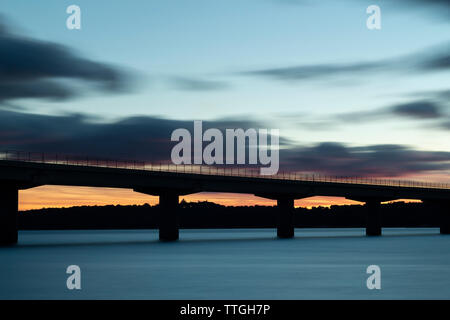 Coucher de soleil après une traversée du viaduc au-dessus d'un lac Banque D'Images