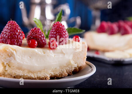 Close-up of cheesecake aux framboises et groseilles rouges servi dans la plaque sur la table Banque D'Images