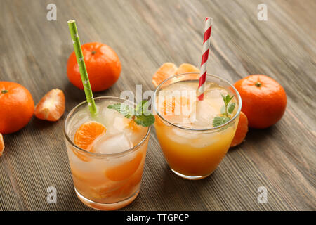 Deux délicieux cocktails mandarine fraîche avec de la glace, la menthe, les pailles et les mandarines sur la table en bois, Close up Banque D'Images