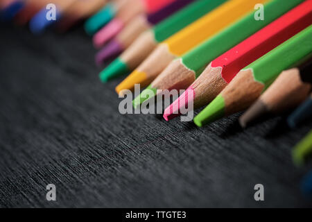 Crayons alignés sur un tableau noir. Banque D'Images