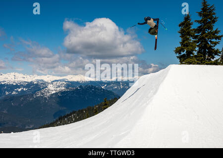 Un homme frappe un saut en skis dans le snowpark à Whistler Blackcomb. Banque D'Images