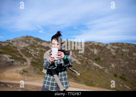 Female hiker taking photo avec téléphone mobile sur une journée ensoleillée Banque D'Images