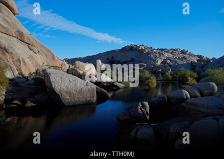 Vue panoramique du lac calme au milieu des rochers contre ciel bleu à Joshua Tree National Park Banque D'Images