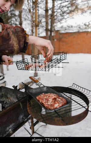 L'homme pour les hamburgers frites magrets. barbecue Banque D'Images