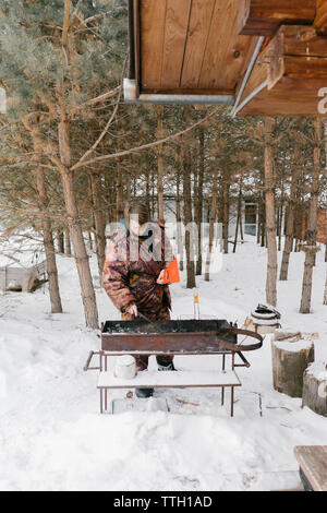 L'homme pour les hamburgers frites magrets. barbecue Banque D'Images